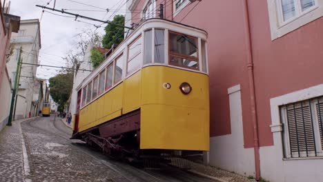 Shot-of-yellow-old-tram-passing-through-Elevador-da-Glo-ria-in-Lisbon,-Portugal