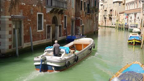 Motorboat-navigating-through-the-canal-of-Venice-city,-Italy