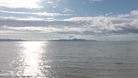 Aerial-track-back-low-over-the-Great-Salt-Lake,-Utah-on-a-sunny-spring-day