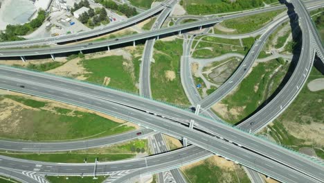 Aerial-drone-footage-reveals-an-intricate-highway-junction-with-cars-navigating-roundabouts-and-intersecting-roads