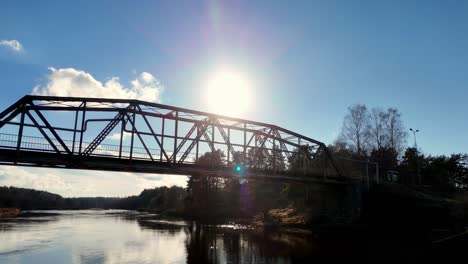 Sonnenaufgang-Skyline-Kontrastiert-Lettische-Stahlbrücke-überquert-Wasser-Fluss,-Stadtluft