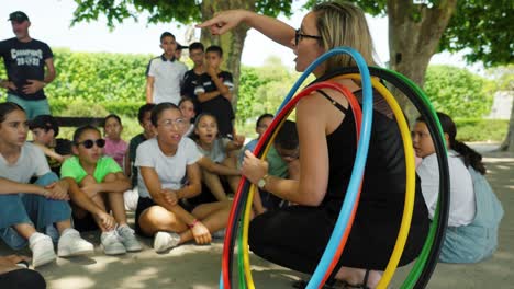 Slow-motion-shot-of-a-teacher-holding-hula-hoops-in-front-of-school-children