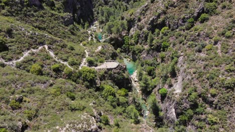 Vista-Aérea-Del-Arroyo-De-Montaña-Con-Aguas-Turquesas,-Mirador-Y-Pasarela-De-Madera-Sobre-El-Río