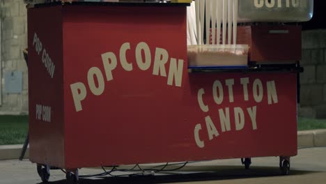 Popcorn-and-cotton-candy-color-red-food-cart,-in-the-warm-summer-evening