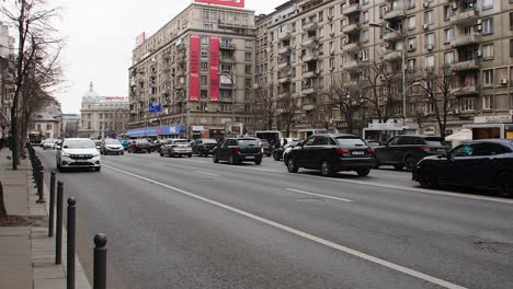 City-traffic-in-downtown-Bucharest-with-modern-and-classic-architecture,-overcast-day