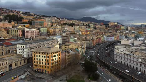 Genoa-showing-bustling-city-and-port-with-dramatic-cloudy-skies,-aerial-view