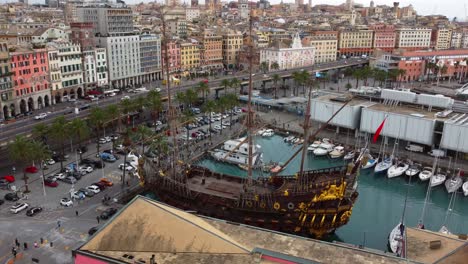 Genoa-port-with-a-historic-ship-and-bustling-cityscape,-italy,-aerial-view