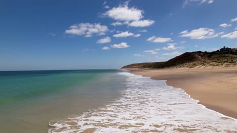 Eine-Drohne-Fliegt-An-Einem-Wunderschönen-Strand-In-Südaustralien-Entlang,-Während-Die-Kleinen-Wellen-Gegen-Das-Ufer-Rollen