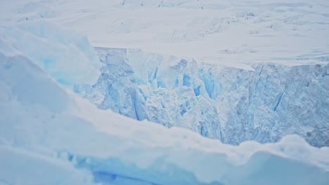 Glaciar-Derritiéndose-Con-Calentamiento-Global-En-El-Paisaje-De-La-Antártida,-Cambio-Climático-En-La-Hermosa-Península-Antártica-En-Una-Fría-Escena-Invernal-Azul-Que-Muestra-Grietas-Y-Detalles-De-Primer-Plano-Del-Derretimiento-Del-Hielo