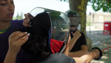 Slow-motion-shot-of-a-help-securing-a-fencers-helmet-before-a-fight