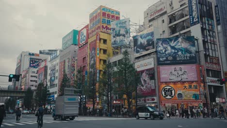 Pedestrians,-Cars,-And-Commercial-Buildings-With-Billboards-In-Tokyo-City,-Japan