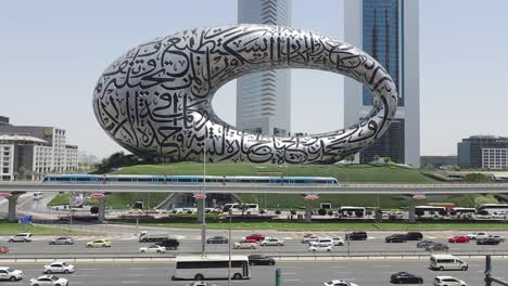 Dubai-traffic-and-the-Dubai-Metro-on-Sheikh-Zayed-Road,-framed-by-the-Museum-of-the-Future-and-the-Emirates-Towers