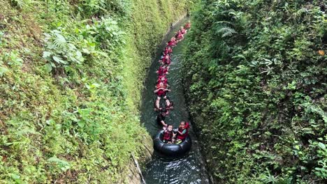 Personas-Con-Chalecos-Salvavidas-Y-Flotando-En-Fila-En-El-Río-De-Montaña