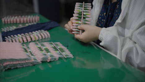 Machine-made-artificial-nails-are-inspected-by-hand-one-by-one-to-ensure-quality