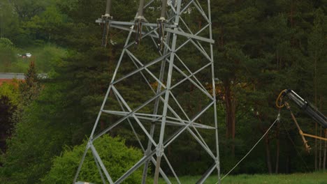 Skilled-workers-installing-a-high-voltage-pole-in-the-city-by-crane