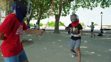 Slow-motion-shot-of-young-children-fencing-trying-to-win-the-fight-in-a-park