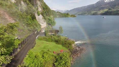 Aerial-view-of-Seerenbach-Falls-near-Amden-Betlis-with-a-vibrant-rainbow-over-Walensee-and-surrounding-lush-greenery-in-Switzerland
