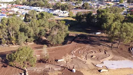 Wide-aerial-orbit-around-new-all-abilities-playground-construction,-Riverlinks-Park-Clarkson