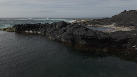 Costa-Rocosa-De-Mosteiros,-Sao-Miguel-Con-Tranquila-Piscina-De-Marea-Y-Paisaje-Accidentado,-Día-Soleado,-Plano-Amplio