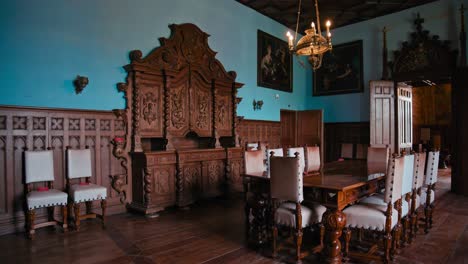 Elegante-Comedor-En-El-Castillo-De-Trakošćan-Con-Tallas-De-Madera-Ornamentadas-Y-Una-Llamativa-Pared-Azul