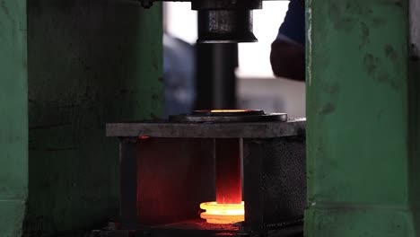 close-up-seen-cross-angle-shot-The-men-are-putting-the-hot-billets-into-the-forging-machine,-Industrial-safety-first-concept