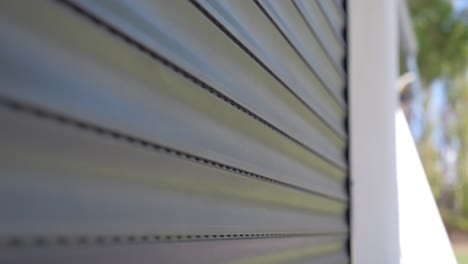 Close-up-shot-of-a-automatic-garage-door-closing-with-bright-sunlight