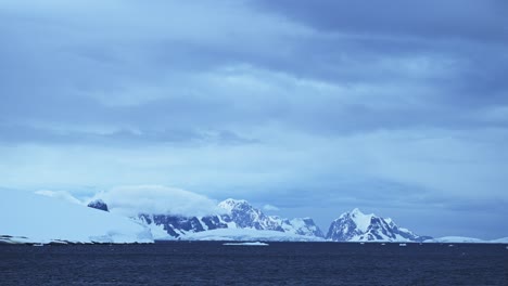 Paisaje-De-Montañas-Invernales-Con-Nieve-Y-Hielo,-Hermoso-Y-Espectacular-Paisaje-Azul-En-La-Antártida-En-La-Península-Antártica,-Condiciones-Climáticas-Frías-Con-Grandes-Montañas