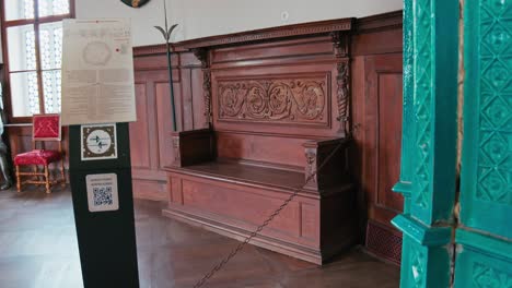 Elaborate-wooden-bench-with-ornate-carvings-in-the-historical-Chivalric-Hall,-Trakoscan-Castle,-Croatia