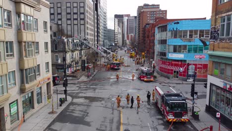 Firefighters-and-emergency-vehicles-at-fire-aftermath,-montreal,-aerial-view