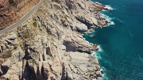 Drone-flying-with-the-coastal-route-revealing-the-beach-in-Cape-Town-South-Africa