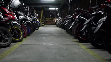 Traveling-down-an-aisle-lined-with-parked-motorcycles-in-a-repair-shop