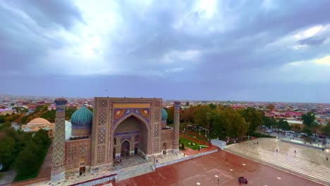 Paisaje-Urbano-Aéreo-La-Plaza-Registan-Es-El-Mejor-Lugar-Para-Descubrir-La-Antigua-Arquitectura-Uzbeka-Y-Disfrutar-De-Las-Grandes-Decoraciones-De-Mosaicos,-Samarcanda,-Uzbekistán