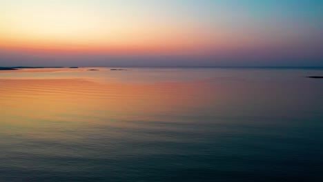 Luftaufnahme-Eines-Farbenfrohen-Sonnenuntergangs-Am-Meer-In-Saco,-Maine,-Mit-Leuchtenden-Farben,-Die-Sich-In-Den-Ruhigen,-Plätschernden-Meereswellen-Entlang-Der-Atlantikküste-Von-Neuengland-Widerspiegeln