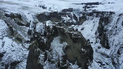 Island-Schlucht-Mit-Hohen-Klippenfelsen-In-Einer-Schlucht-In-Island,-Bedeckt-Mit-Schnee-Und-Eis