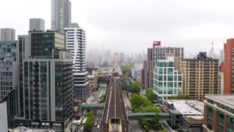 Aerial-Boom-Shot-Above-Subway-Tracks-in-New-York-City,-Reveals-Queensboro-Bridge-in-Queens
