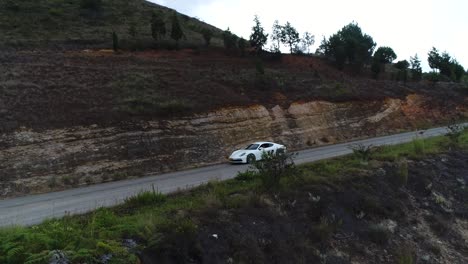 aerial-shot-of-a-moving-porsche-cayman-in-a-twisty-colombian-road