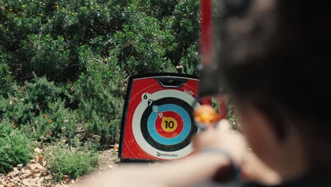 Toma-En-Cámara-Lenta-De-Un-Niño-Haciendo-Prácticas-De-Tiro-Con-Arco-Con-Flechas-De-Ventosa