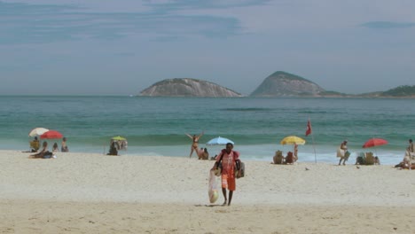 Arbeiter-Mann-Zu-Fuß,-Um-Mate-Tee-Am-Strand-Von-Ipanema-Zu-Verkaufen-An-Einem-Sonnigen-Tag