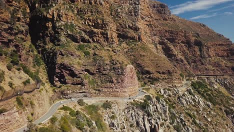 Drone-Siguiendo-Una-Ruta-Panorámica-Con-Automóviles-Que-Revelan-El-Borde-Costero-En-Ciudad-Del-Cabo,-Sudáfrica