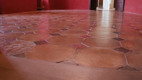 Close-up-view-of-the-geometrically-patterned-floor-tiles,-aged-and-worn,-in-Trakošćan-Castle's-family-hall