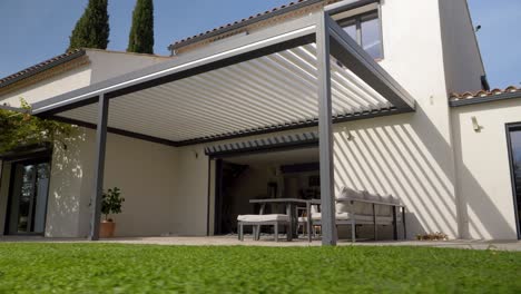 Low-Angle-Aufnahme-Eines-Sonnenschirms-Mit-Gartenmöbeln-Vor-Einer-Villa