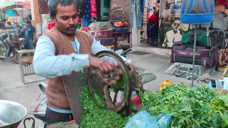 Männlicher-Anbieter-Verwendet-Kurbelrad-In-Zerkleinern-Von-Gemüse-Auf-Der-Straße-In-Delhi,-Indien