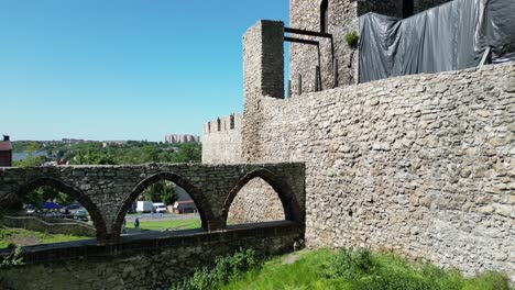 Medieval-Bedzin-castle-with-a-turret,-white-stone-walls,-and-courtyard-during-a-beautiful-summer-day-surrounded-by-lush-greenery,-under-a-clear-blue-sky