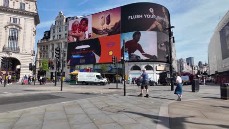 Sunny-day-at-Piccadilly-Circus,-London-with-pedestrians-and-digital-billboards,-wide-shot