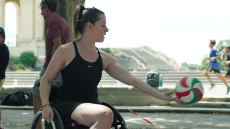 Slow-motion-shot-of-a-disabled-woman-passing-a-ball-in-handball-to-kids