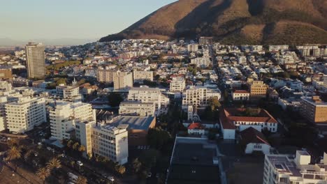 Drone-Volando-Hacia-Arriba-Revelando-Los-Edificios-De-La-Ciudad-Cerca-De-La-Costa-De-Ciudad-Del-Cabo,-Sudáfrica