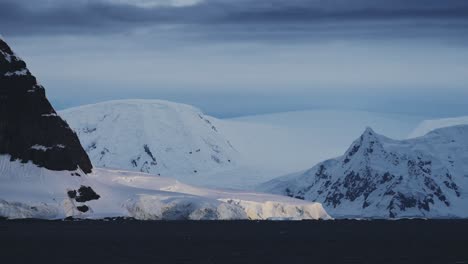 Antarctica-Winter-Mountains-Coastal-Scenery,-Cold-Blue-Landscape-with-Glacier-Ice-Cap-and-Ocean-Sea-Water-on-Coast,-Antarctic-Peninsula-Seascape-in-Dramatic-Moody-Blue-Atmospheric-Scene