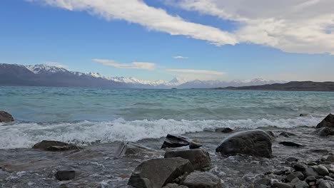 Scenic-shot-of-rolling-waves-at-lake-Pukaki-crashing-on-the-rocky-shore