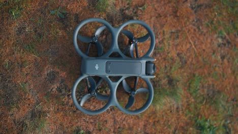 Top-down-view-of-person-push-power-button-to-turn-on-compact-FPV-drone