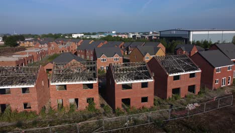 Residential-housing-framework-aerial-view-flying-over-unfinished-rooftop-development-on-urban-building-site-real-estate